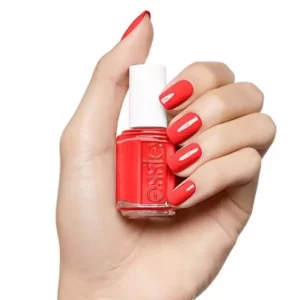 Hand with red nails hold Essie Nail Polish bottle 13.5ml 558 Come Here